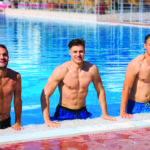 Three man getting out of swimming pool and smiling